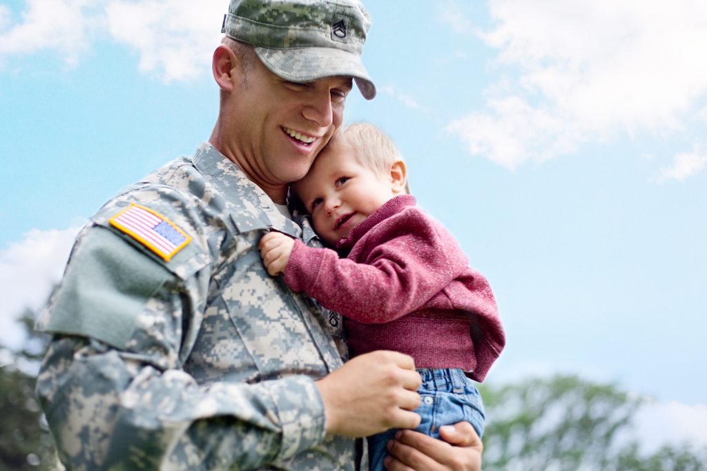 Soldier Holding Child - Patterson Behavior Services